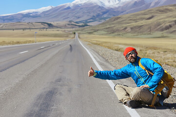 hiker with backpack on the highway hitchhiking, travel activity trip