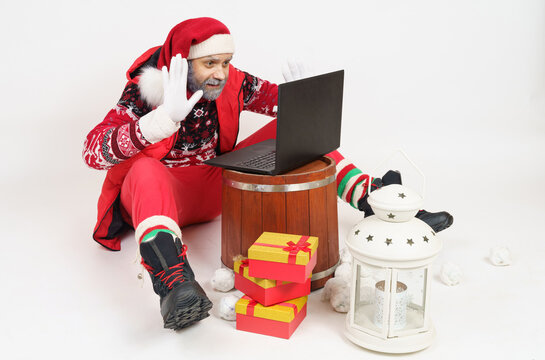Santa Claus communicates online through a laptop.