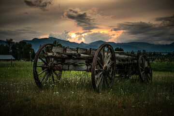 Wagon in the field with sunset - obrazy, fototapety, plakaty