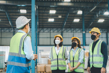 Group of working staff in face medical mask having safety meeting at factory