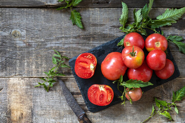 Organic healthy raw ripe pink tomatoes on a kitchen wooden table. The concept of Diet menu and harvesting. Top view flat lay background. Copy space.