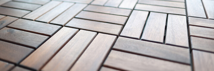 Wooden brown tiles lying on floor closeup