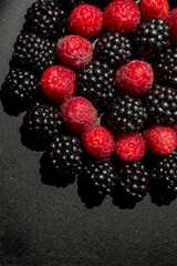 Summer berries. Ripe raspberries and blackberries. Healthy eating. Healthy foods. Juicy berries for dessert. Background for cafe and restaurant. Delicious still life. Seasonal products. Red and black.
