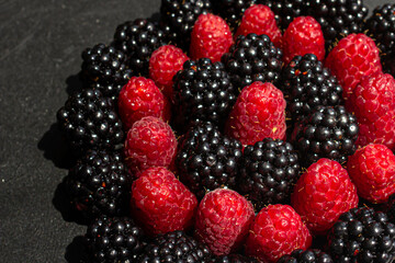 Summer berries. Ripe raspberries and blackberries. Healthy eating. Healthy foods. Juicy berries for dessert. Background for cafe and restaurant. Delicious still life. Seasonal products. Red and black.