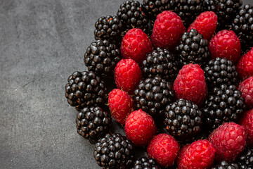 Summer berries. Ripe raspberries and blackberries. Healthy eating. Healthy foods. Juicy berries for dessert. Background for cafe and restaurant. Delicious still life. Seasonal products. Red and black.