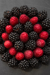 Summer berries. Ripe raspberries and blackberries. Healthy eating. Healthy foods. Juicy berries for dessert. Background for cafe and restaurant. Delicious still life. Seasonal products. Red and black.