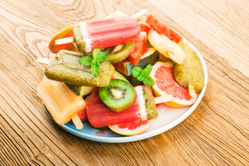 Healthy Whole Fruit Popsicles with Berries Kiwi watermelon cantaloupe on wooden vintage table