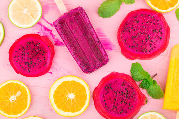 Various fresh fruit popsicles placed on wooden board background