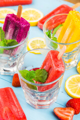 Healthy Whole Fruit Popsicles with Berries Kiwi watermelon cantaloupe on wooden vintage table