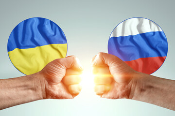 Male hands show their fists against the background of the flags of Ukraine and Russia. The concept of power struggle, conflict of interest, war, sanctions, cold war, economic struggle.