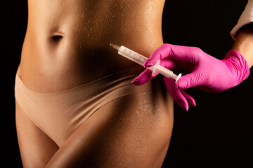 cosmetologist makes lipolytic injections to burn fat on the stomach and waist of a woman. Female...