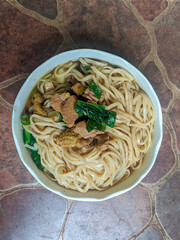 delicious chicken noodle with white bowl, with chicken and green vegetables composition