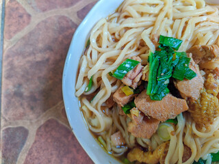 delicious chicken noodle with white bowl, with chicken and green vegetables composition
