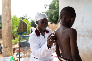 Pediatric home visit from the to an african family to check the general health status of an ill black schoolboy with a suspected infectious disease - obrazy, fototapety, plakaty