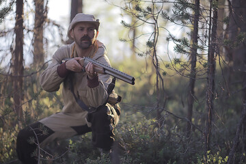 Fototapeta premium man goes hunting forest summer / landscape in the forest, huntsman with a hunting rifle hunts