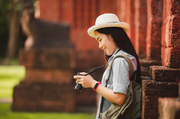 Photographer holding camera on tourist attraction in warm sunset.