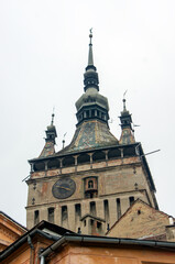 Fototapeta premium Clock on facade of derelict tower with steeple above, Sighisoara, Romania