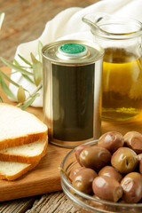 Olives, olive oil and bread on wooden rustic table.
