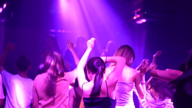 Women and men have fun in dance party. Group of young people dancing in night club.