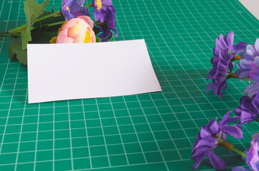 White paper card on green cutting board .