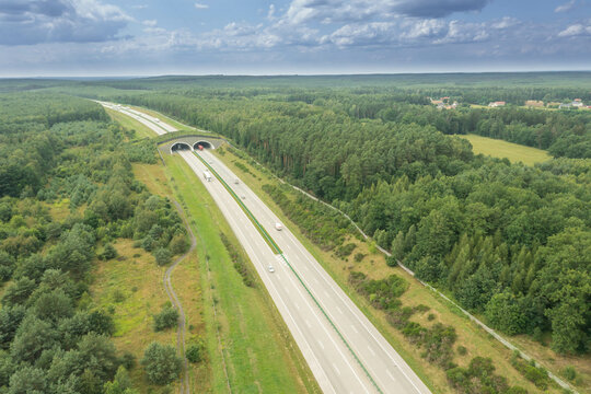 Betonowa autostrada przebiegająca przez las. Zdjęcie wykonane z wysokości przy użyciu drona.