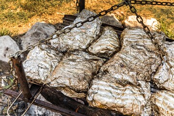 Meat Grilled in Foil on Flaming BBQ Grill. Barbecue cooking flaming grill grid Food Background in...