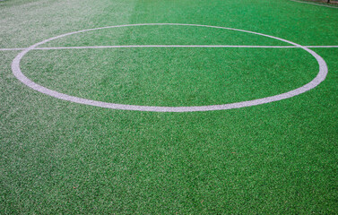 Obraz premium The centre of soccer field with artificial green grass and white lines near the school. Amateur football field. Sunny summer day