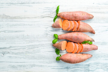 Sweet potatoes on a white wooden background. Dietary food. Top view. Free space for your text.