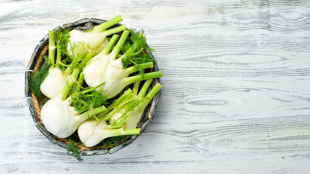 Fresh organic fennel bulbs in a wooden box. Healthy food. Top view. Free space for your text.