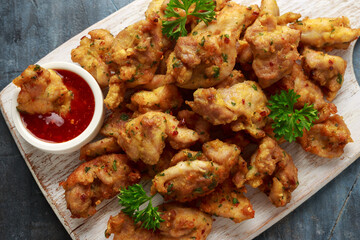 Chicken Pakora dish with sweet chilli sauce on white wooden board