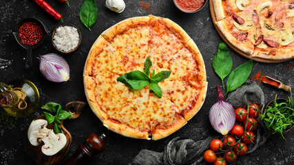 Traditional pizza with cheese and tomato sauce. On a black stone background. Free space for text.