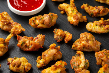 Chicken Pakora dish with sweet chilli sauce on rustic stone board