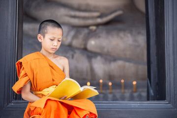 Young novice monk reading a book in Wat Phutthai Sawan Temple, Ayutthaya