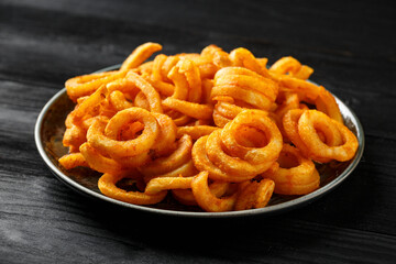 Golden Spicy Seasoned Curly Fries on rustic plate. ready to eat