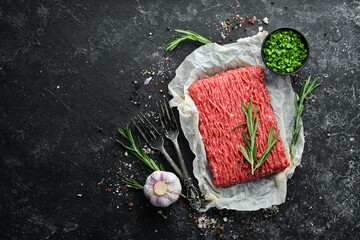 Raw minced meat on a black surface. Top view. Free space for your text.