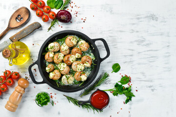 Bourgogne Escargot Snails with garlic, cheese in a creamy sauce on a black stone plate. Top view. Free space for text.