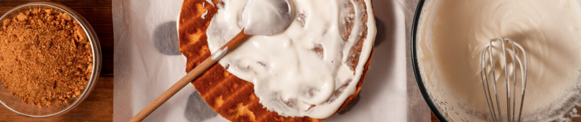 Bakery ingredients and kitchen utensils on wooden rural kitchen table for baking thematic background.