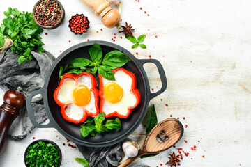 Fried scrambled eggs with sweet pepper in a pan. Top view. Free space for your text.