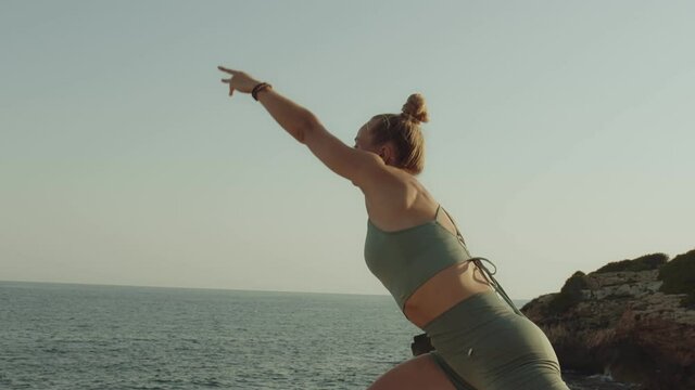 Vinyasa yoga poses sequence practice near mediterranean sea. Mindfulness and body care. Calm meditative ambient. Panned shot slow motion high quality video footage.