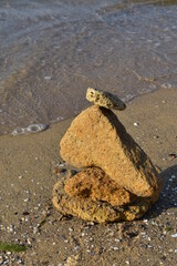 composition on balance of stones against the background of sand and sea