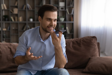 Leading innovations. Confident male speaker record audio file on smartphone use voice app...