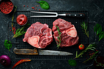 Osso buco Veal steak with rosemary and spices. On a black background. Top view.