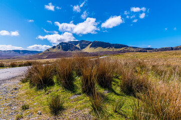 A view along the road towards the Quiraing Mountains in the distance on the Isle of Skye, Scotland on a summers day