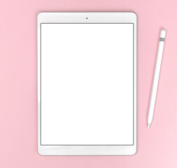 Desk pink workspace with tablet and stylus, blank white screen office mockup, top view and copy space photo