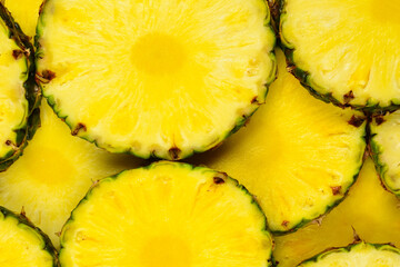 Pineapple juicy yellow slices background. Top view.