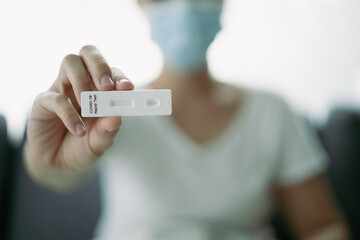 Asian woman using COVID-19 ag testing.