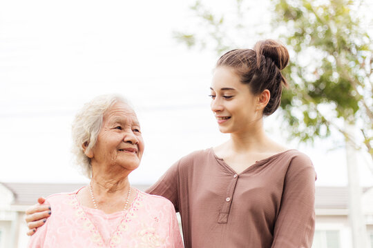 Happy elderly woman with a caregiver in the garden, Home care concept...