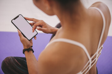 Woman using cellphone after yoga workout