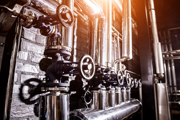The valves and pipes at a craft modern brewery wall