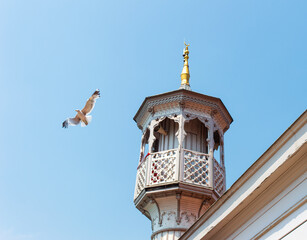 Fototapeta na wymiar Minaret of a Muslim mosque with seagull on the clear blue sky background